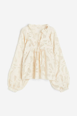 Blusa en tejido texturizado con mangas globo