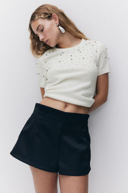 Top en punto fino con detalles decorativos