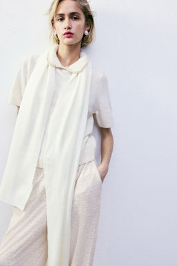 Top de punto con cuello de cuentas