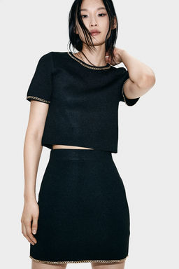Top de punto con cadena decorativa