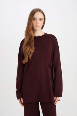 Женский однотонный трикотажный свитер-туника стандартного кроя с круглым вырезом и завязками по бокам