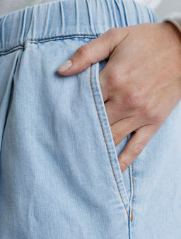 Широкие джинсы с поясом на резинке и с защипами из облегченного денима