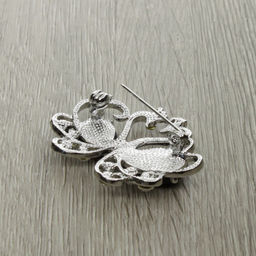 Брошь "Влюбленные лебеди" со вставками из гелиотиса и ювелирного сплава