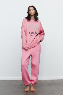 WASHED-EFFECT PLUSH TROUSERS WITH SLOGAN