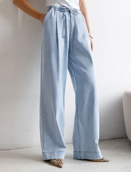 Широкие джинсы с поясом на резинке и с защипами из облегченного денима