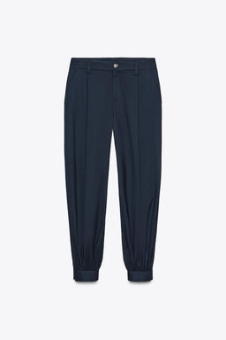 PLEATED TROUSERS WITH BUTTONED HEM