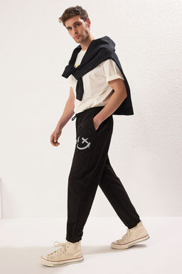 TRENDYOL MAN Siyah Oversize/Genis Kesim Lastik Paca Gulen Yuz Bask?l? Jogger Esofman Alt? TMNSS22EA0119