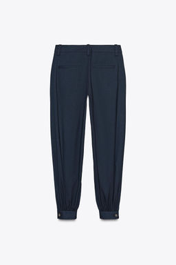 PLEATED TROUSERS WITH BUTTONED HEM